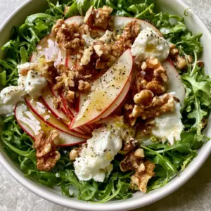 Close-up of Apple Arugula Salad with translucent Honeycrisp slices and shimmering lemon balsamic vinaigrette.