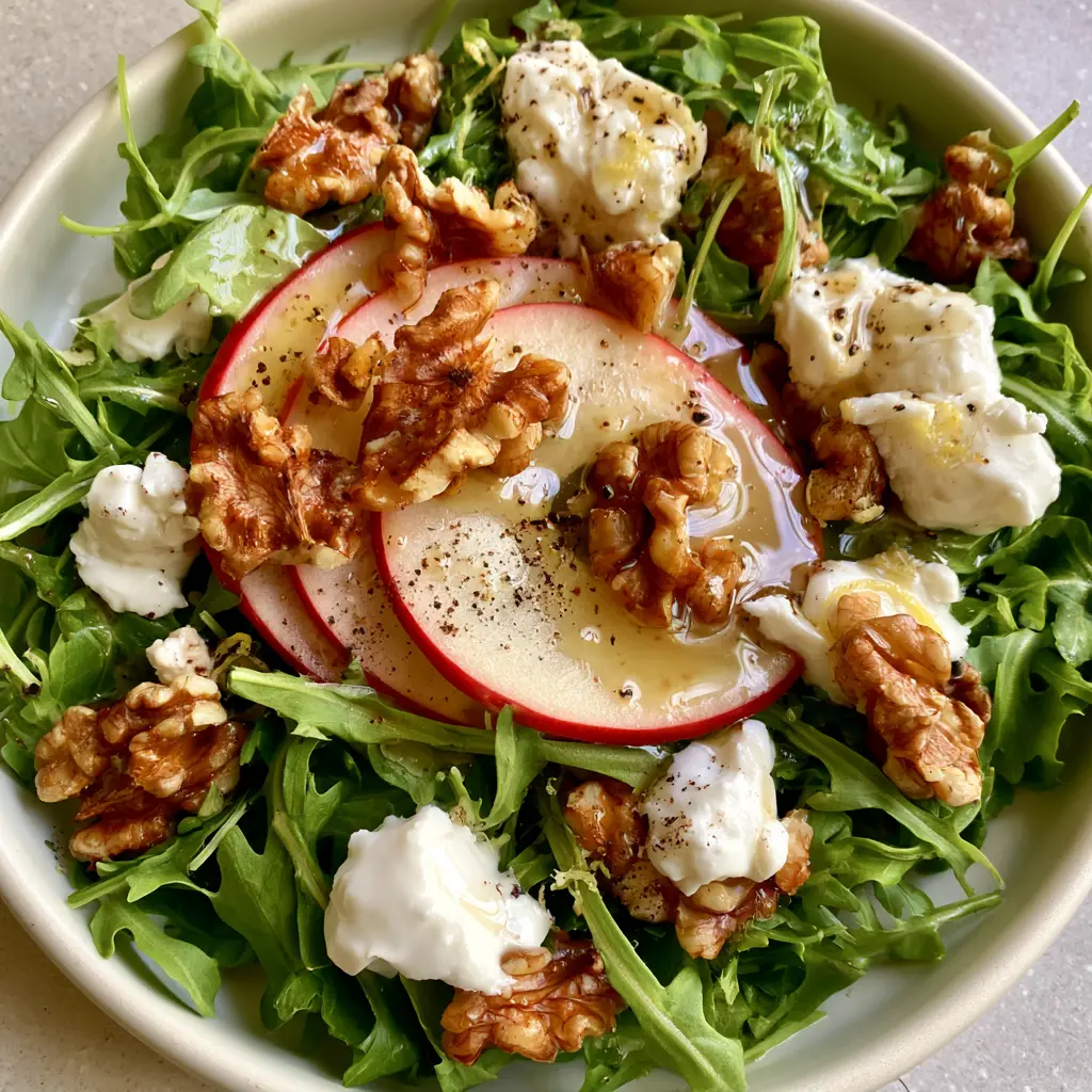 Apple Arugula Salad with Lemon Balsamic Vinaigrette and Goat Cheese 1 Top-down view of Apple Arugula Salad showing jagged toasted walnuts and creamy goat cheese dollops.